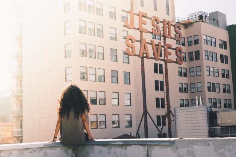Woman overlooking city with Jesus Saves