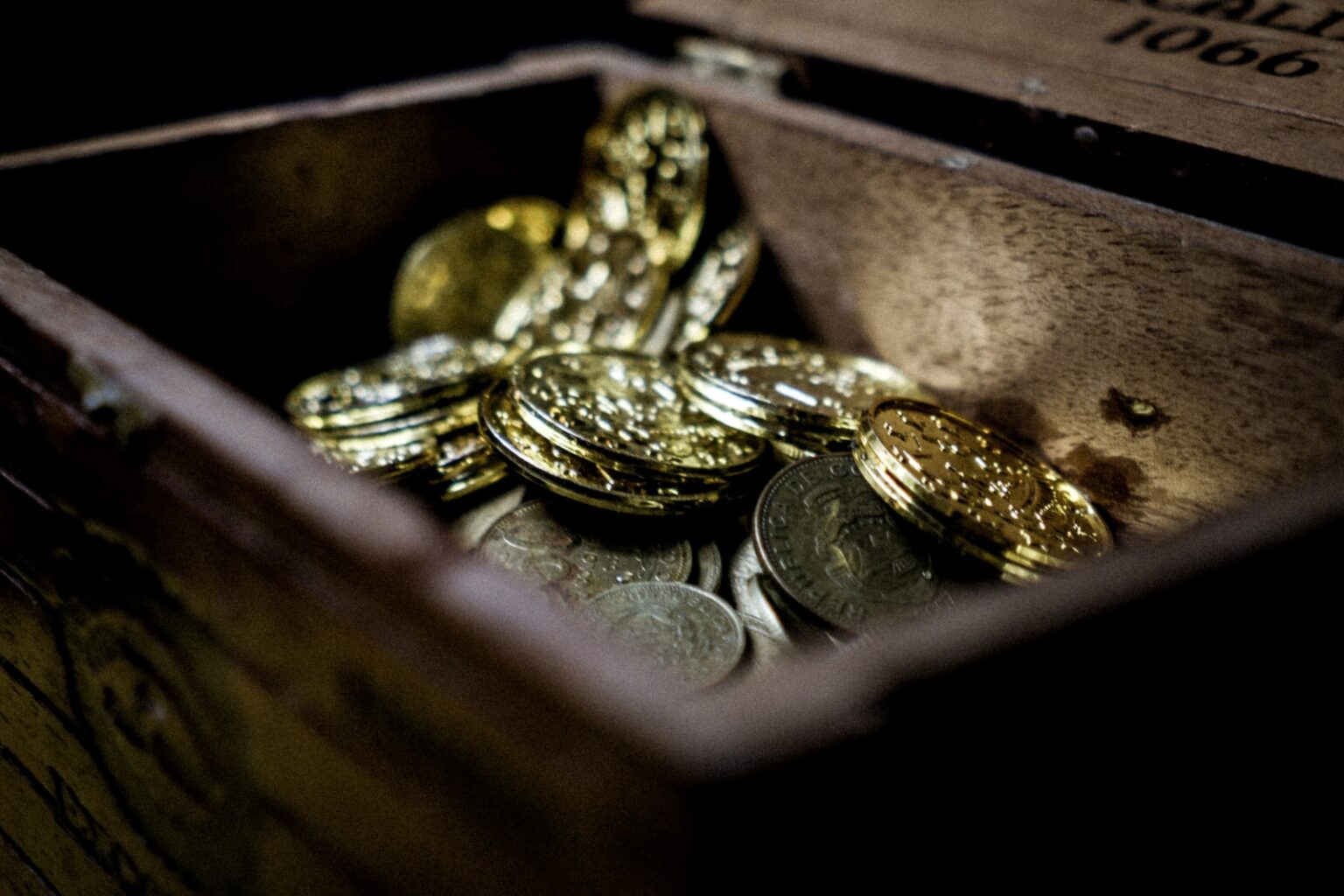 a wooden box filled with lots of coins